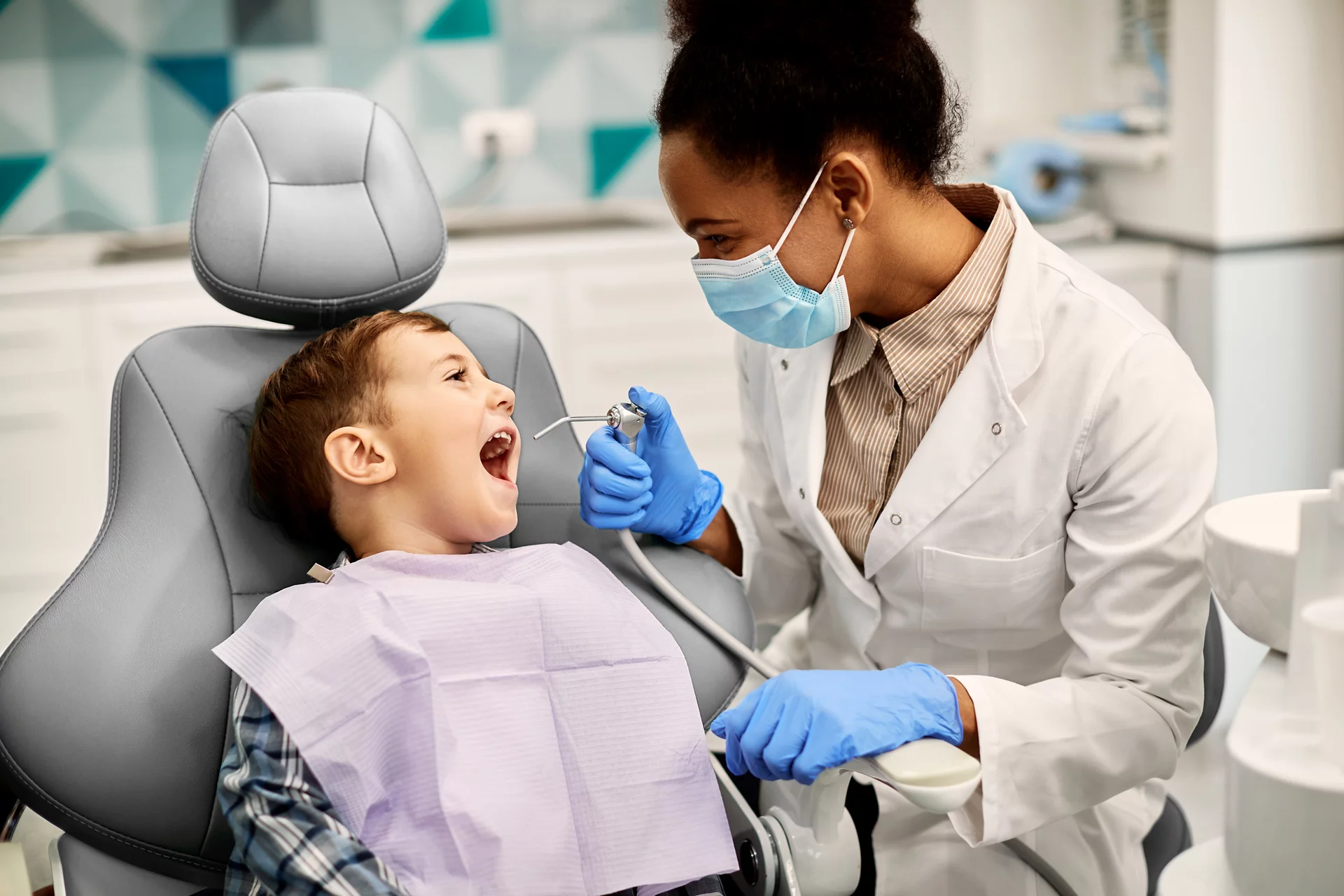 Dentist and working on boy in dentist chair